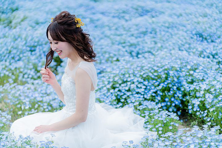 桜並木の中で立つ新婦
