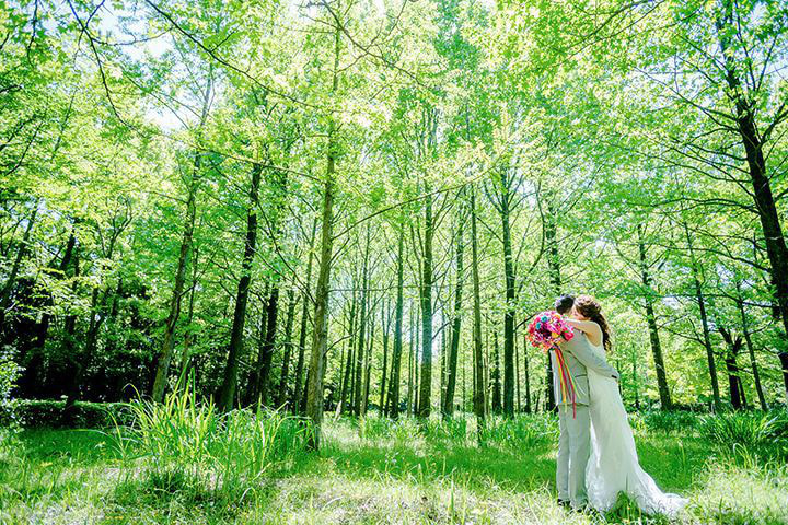 桜並木の中で立つ新婦